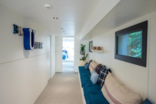 un salon avec un canapé bleu et une télévision dans l'établissement La Rivière House - Péniche Carpe Diem, à Nantes