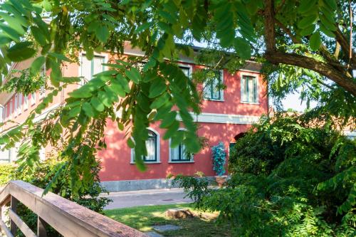 a red building with a tree in front of it at Hotel Silver Milano in Milan