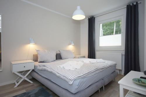 ein Schlafzimmer mit einem Bett und einem Fenster in der Unterkunft Ferienwohnung Windherz in Ostseebad Sellin