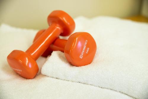 a pair of orange dumbbells sitting on top of towels at Hotel Silver Milano in Milan