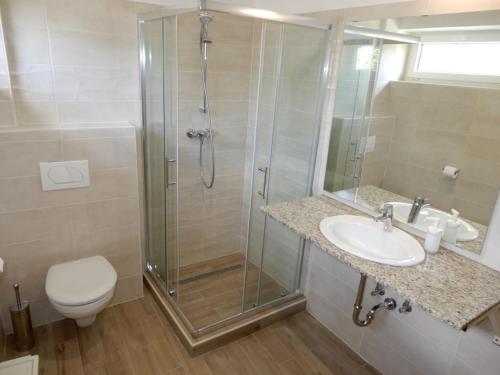 a bathroom with a shower and a sink and a toilet at Rómahegy Rendezvényház in Kaposvár