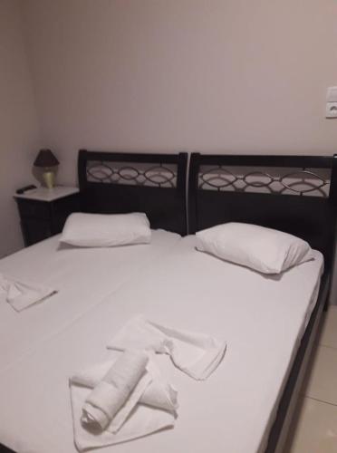 a bed with white sheets and white pillows at Hotel Pegasos in Nikiana