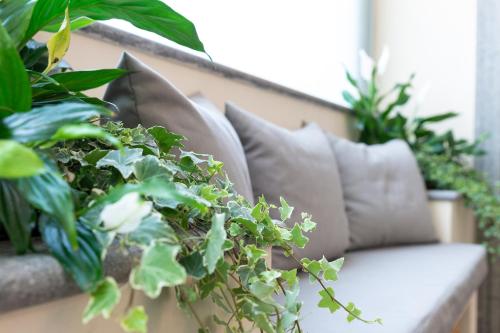 a couch sitting on a balcony with plants at Hotel Silver Milano in Milan