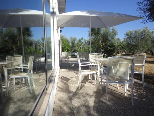 a group of tables and chairs with an umbrella at B&B Masseria Liberatore in Mattinata