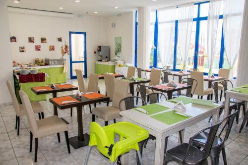 a dining room with tables and chairs and windows at Olympic Suites in Rethymno Town