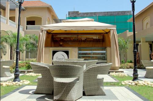 a group of wicker chairs and a table with an umbrella at Pramod Convention & Club Resort in Cuttack