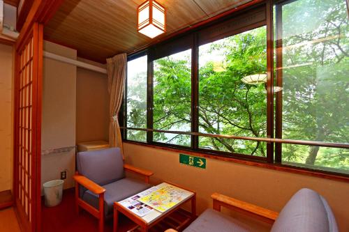 a room with a chair and a table and a window at Hounkan in Yoshino