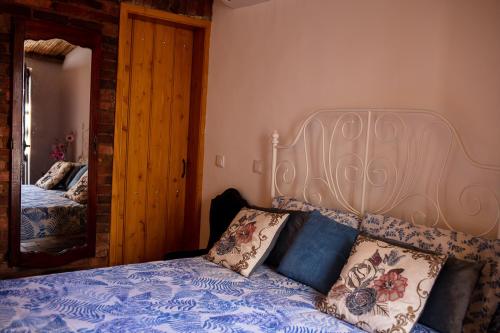 a bedroom with a bed with a blue comforter and a mirror at Typical fishing village in historic center I in Portimão