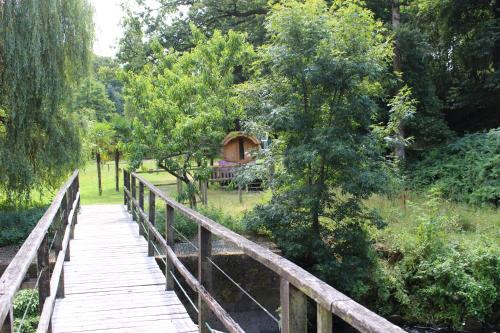 a wooden bridge over a field with a gazebo at Moulin de Bray - Chambres d'hotes et hébergement Insolite in Vieux-Vy-sur-Couesnon