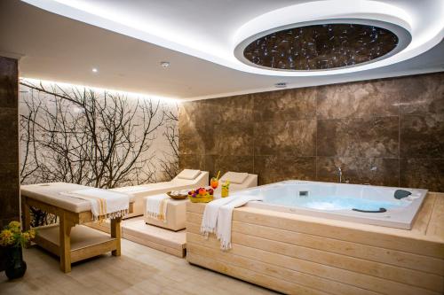 a bathroom with a large tub in a room at Suna Sun Hotel - Adult Only in Kaş
