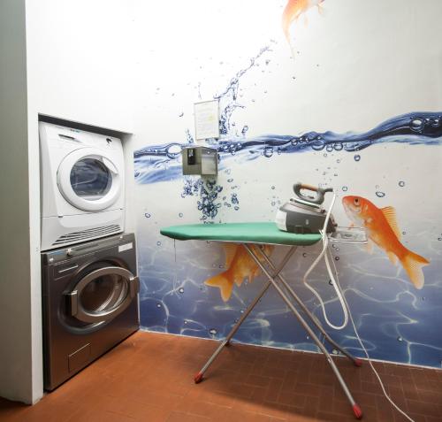 a room with a washing machine and a fish mural at Residence Star in Turin