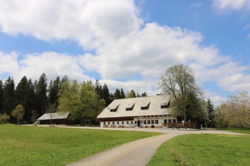 a large white barn with a road in front of it at Gasthaus Staude in Triberg