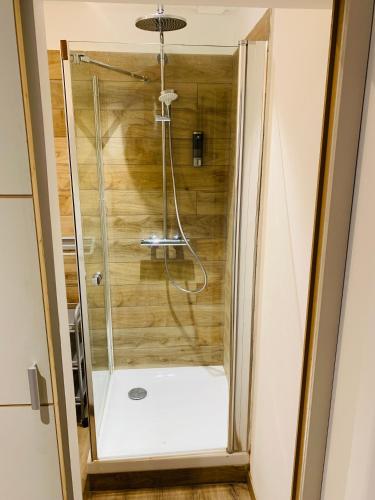 une douche avec une porte vitrée dans une salle de bain dans l'établissement Cassis Studio, à Aix-en-Provence