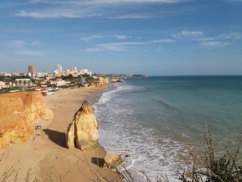 a view of a beach with rocks and the ocean at Typical fishing village in historic center I in Portimão