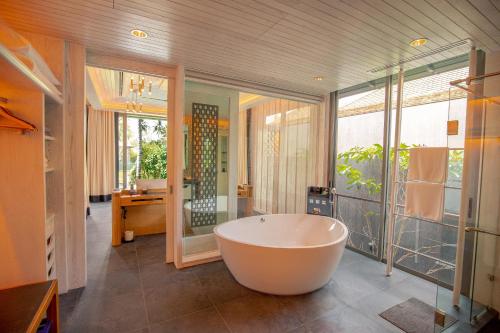 a large bathroom with a tub and a large window at Baba Beach Club Natai Luxury Pool Villa Hotel by Sri panwa - SHA Plus in Natai Beach