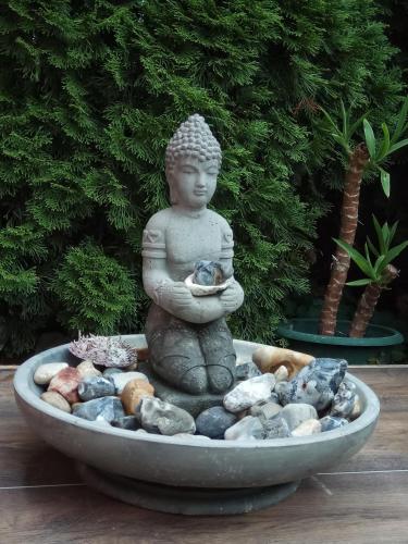 a statue of a buddha sitting in a fountain at Károlyi Panzió in Eger