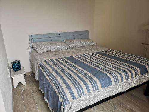 a bedroom with a bed with a blue and white striped blanket at Agriturismo LaValleggia in Tovo San Giacomo