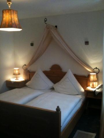a bedroom with a canopy bed with two lamps at Hotel,Gasthaus zum Wenden in Wendelstein