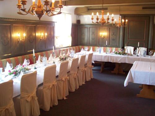 a large room with white tables and white chairs at Hotel,Gasthaus zum Wenden in Wendelstein
