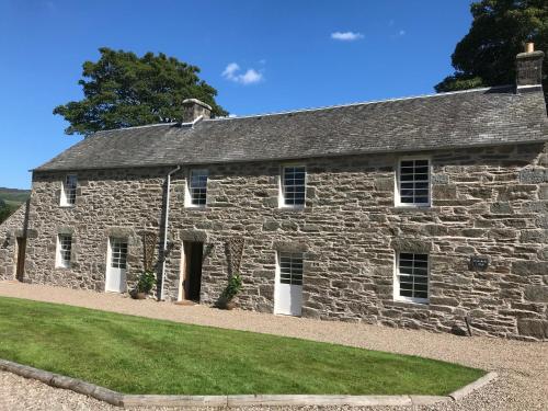 an old stone building with grass in front of it at Brandoch Lodge in Logierait