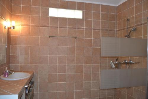 een betegelde badkamer met een wastafel en een douche bij Zoro LOCDENIA in Denia