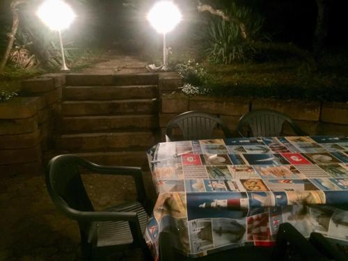 a table with chairs and a table with a newspaper on it at Várhegy Vendégház in Fonyód
