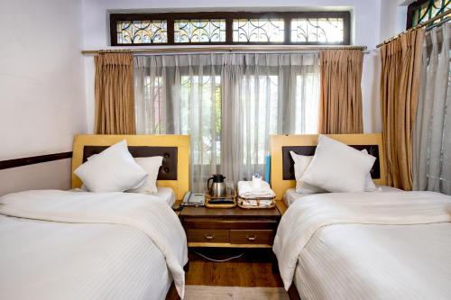 a bedroom with two beds and a window at Shangrila Boutique Hotel in Kathmandu