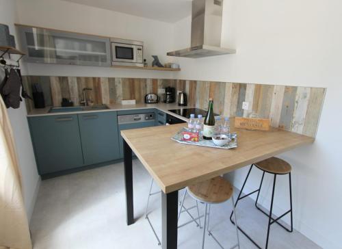 uma cozinha com armários azuis e uma mesa de madeira em Au Mont Chez Nous Jaccuzi et Sauna em Pontorson