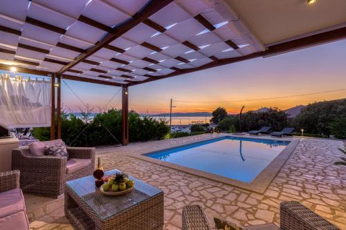a house with a swimming pool and a patio at Villa Gellia in Ugljan