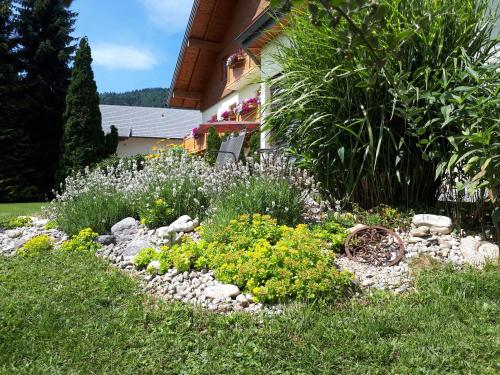 a garden with rocks and flowers in front of a house at Pension Kreuzinger, 5310 Tiefgraben in Mondsee