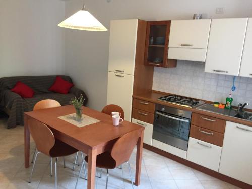 uma cozinha com uma mesa de madeira e uma cozinha com um sofá em Costa Verde Apartment em Predore