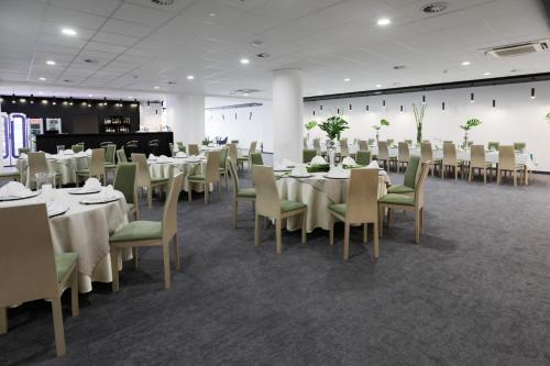 a dining room with white tables and chairs at Hotel Sport in Bełchatów