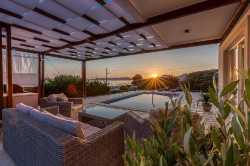 a patio with wicker chairs and a swimming pool at Villa Gellia in Ugljan