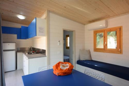 a small kitchen with a blue bench in a tiny house at Camping Fano in Fano