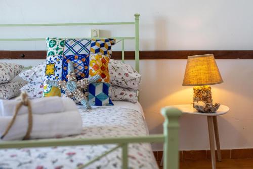 a lamp on a table next to a bed with pillows at Madonna della Scala in Castellabate