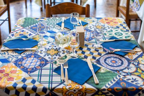 a table with blue and white plates and wine glasses at Madonna della Scala in Castellabate