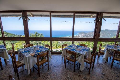 a room with tables and chairs with a view of the ocean at Madonna della Scala in Castellabate