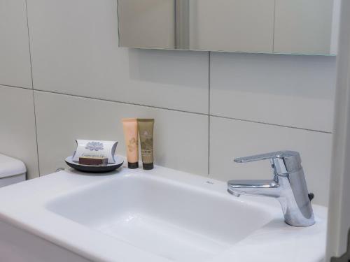 a white bathroom sink with a mirror above it at Sónia's Costa da Caparica apartment in Costa da Caparica