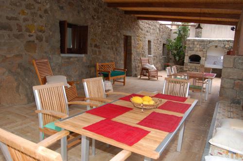 una mesa de madera con un bol de fruta en el patio en La Stele di Rekale en Scauri