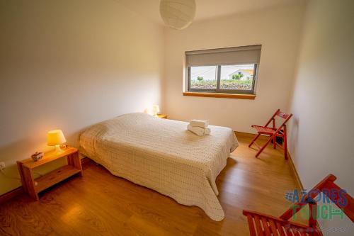 ein kleines Schlafzimmer mit einem Bett und einem Fenster in der Unterkunft Casa da Barra in Santa Cruz da Graciosa