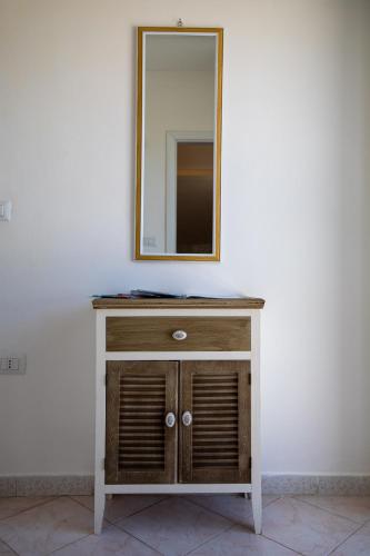 a wooden dresser with a mirror on a wall at Madonna della Scala in Castellabate