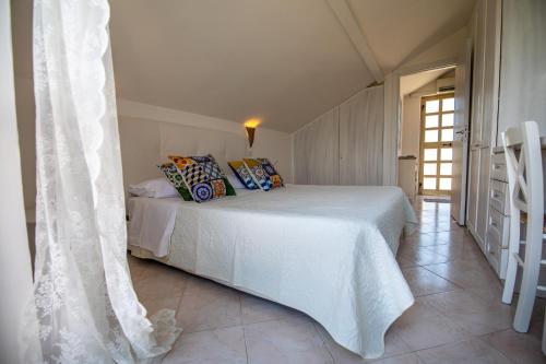 a bedroom with a white bed with pillows on it at Madonna della Scala in Castellabate
