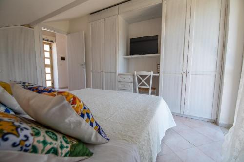 a bedroom with a white bed and a television at Madonna della Scala in Castellabate