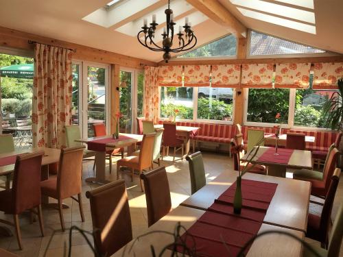 un restaurant avec des tables, des chaises et des fenêtres dans l'établissement Gasthof Lindenwirt, à Denkendorf