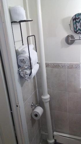 a bathroom with a toilet paper roll and towels at STUDIO and ONE BEDROOM APARTMENTS in Bronx