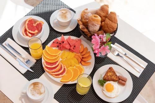 een tafel met borden vol ontbijtproducten en drankjes bij Hotel Palia Maria Eugenia in Calas de Mallorca