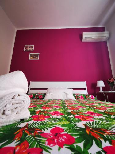 a bedroom with a bed with a flower blanket at Nonna Francesca in Patti