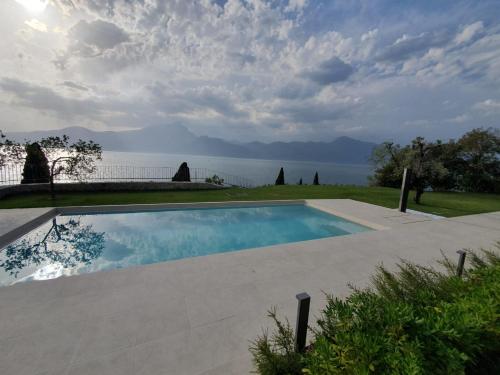 a swimming pool with a view of the water at Le Rocce in Torri del Benaco