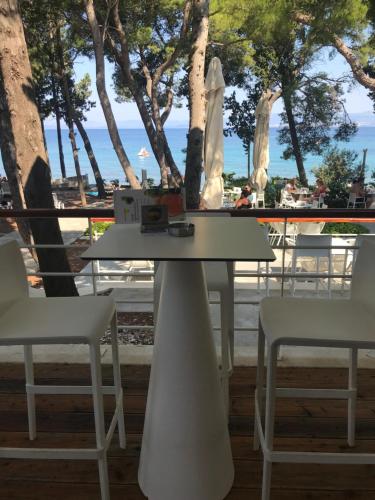 einen Tisch und zwei Stühle vor einem Strand in der Unterkunft Apartments Serenity in Supetar