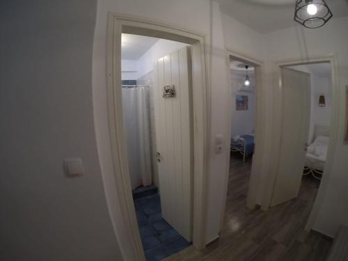 pasillo con puerta blanca y espejo en Fantastic Cycladic Maisonette Olga in Naoussa, en Naousa